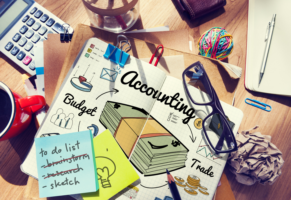 Notebook with accounting concept sketch on messy desk